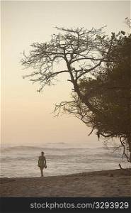 Woman walking along Mal Pais coastline in San Jose Costa Rica