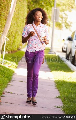 Woman Walking Along Street To Work Listening To Music