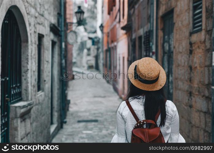 woman walking by tight streets of kotor, montenegro. woman walking by tight streets of kotor