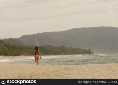 Woman walking down beach