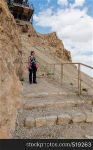 woman walking down the 800 steps of the masada mountain in israel. womam walking from masada mountain