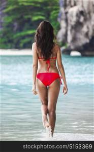 Woman walking in lagoon water. Woman in bikini walking in lagoon water in Thailand, rear view