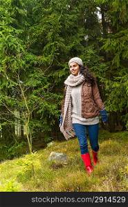 Woman walking in pinewood autumn wear knitted scarf and hat