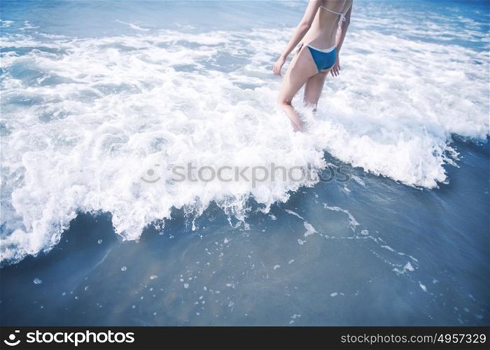 Woman walking into waves at the beach