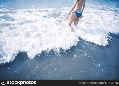 Woman walking into waves at the beach