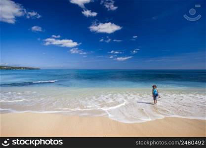 Woman walking on a beautiful white sand tropical beach 