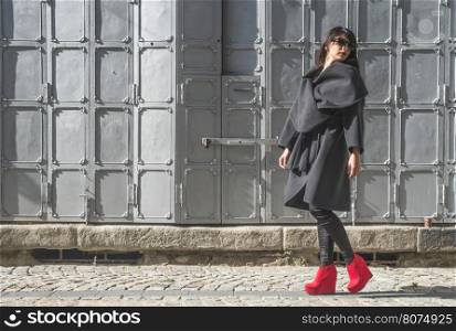Woman walking on a street. Grey background. Bulgaria