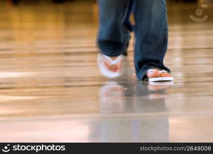 Woman walking on airport terminal, low section