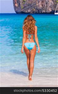 Woman walking on beach. Beautiful woman in bikini on beach in Thailand