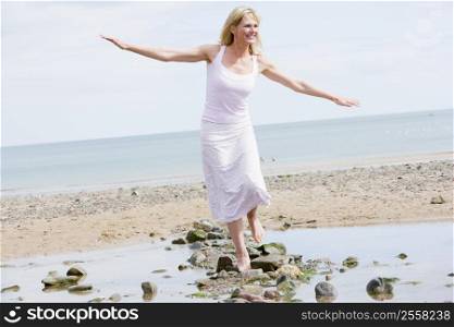Woman walking on beach path smiling