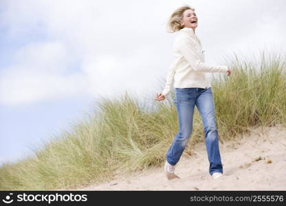 Woman walking on beach smiling