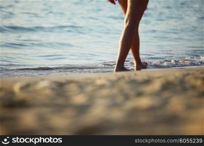 Woman walking on beach. Woman walking along the tropical beach barefoot