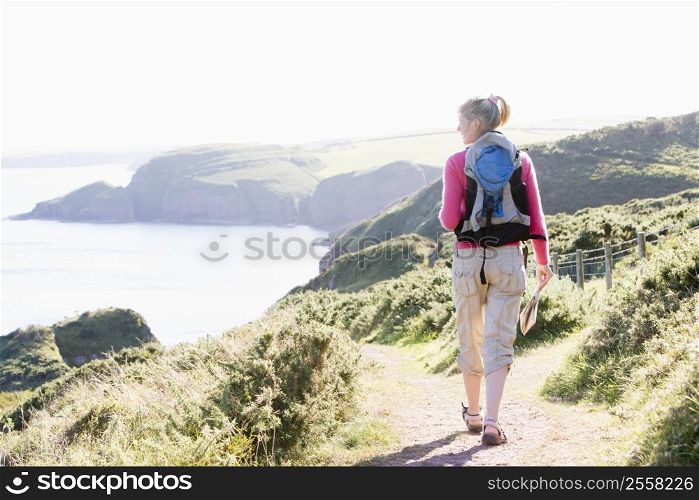 Woman walking on cliffside path