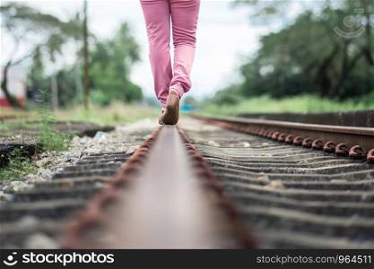 woman walking on railroad tracks