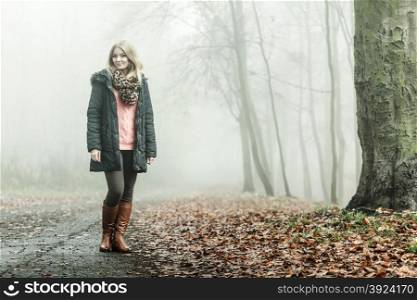 Woman walking relaxing in foggy day in romantic autumn forest park outdoor, tinted aged photo