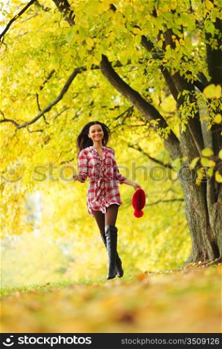 Woman walking through autumn leaves