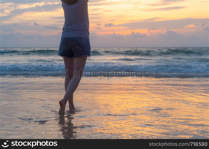 Woman walking to the beach during travel holidays vacation outdoors at ocean or nature sea at sunset time, Phuket, Thailand
