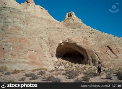 Woman walking towards Ulrike&acute;s Cave, Amangiri, Canyon Point, Utah, USA