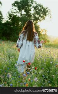 Woman walks in meadow scenic photography. Cornflower field. Picture of lady with beautiful nature on background. High quality wallpaper. Photo concept for ads, travel blog, magazine, article. Woman walks in meadow scenic photography
