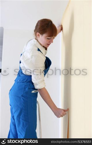 Woman wallpapering her room