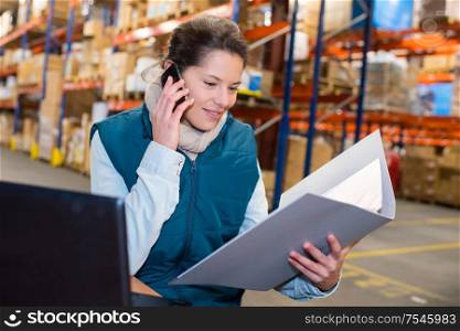 woman warehouse worker or supervisor with smartphone