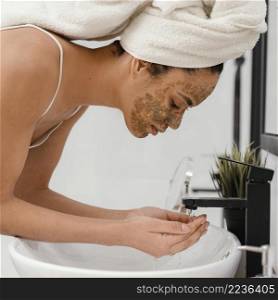woman washing her face after having homemade mask