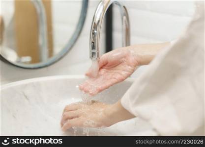 Woman washing her hands, focus water on finger