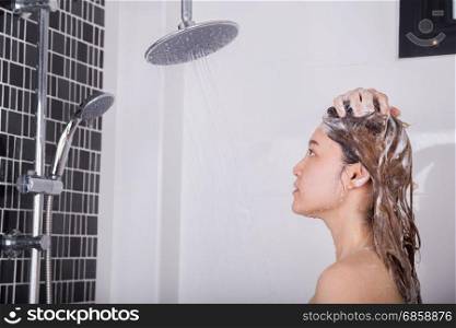 woman washing her head and hair by shampoo