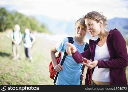 Woman watching a compass with boy