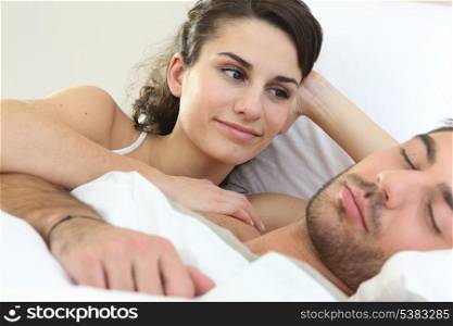 Woman watching her partner sleep