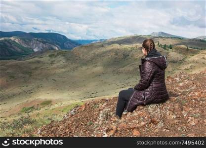 Woman watching to glacier in Altai mountains. Resting in mountains or global warming concept. Woman in the mountain
