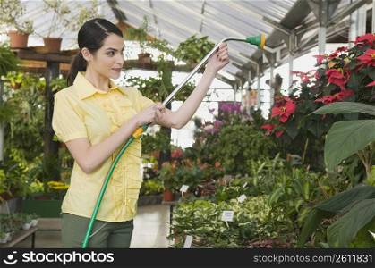 Woman watering plants in a garden center