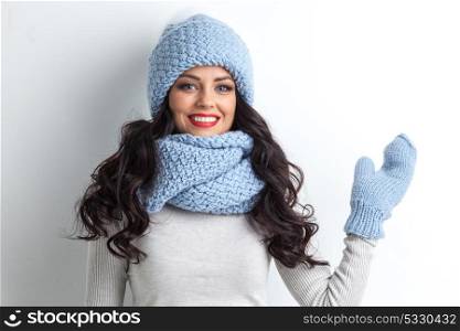 Woman waving hand. Beautiful woman in warm hat, mittens and scarf waving hand