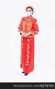Woman wear Cheongsam suit and black shoe with mask for protecting covid-19