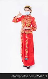 Woman wear Cheongsam suit and mask show the best way to shopping for protecting disease