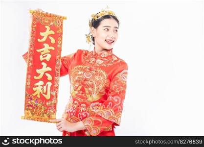 Woman wear Cheongsam suit give family the chinese greeting card for luck in chinese new year