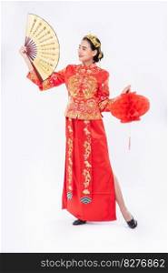 Woman wear Cheongsam suit promote the chinese hand fan and red l&on big event in chinese new year