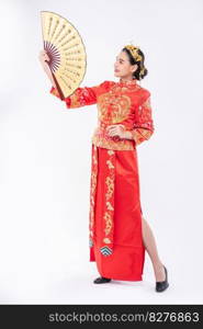 Woman wear Cheongsam suit show the chinese hand fan on big event in chinese new year 