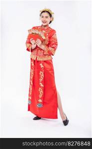 Woman wear Cheongsam suit smile for welcome lucky to get gift money in chinese new year