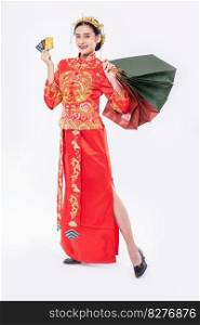 woman wear Cheongsam suit smile to use credit card shopping in chinese new year