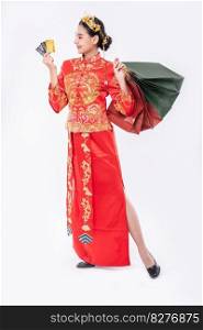 Woman wear Cheongsam suit smile to use credit card  to shopping  in chinese new year