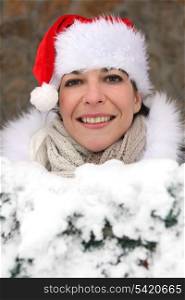 Woman wearing a festive hat whilst in snow