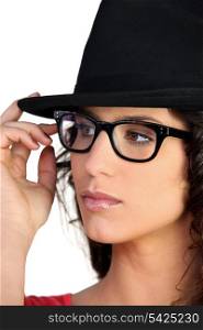 Woman wearing a hat and thick-framed glasses