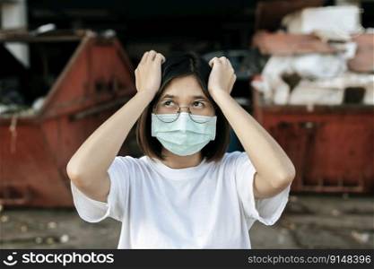 Woman wearing a mask and two hands holding head. Selective focus.