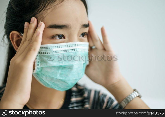 Woman wearing a striped shirt, wearing a mask and a handle on the tail of the eyebrows.