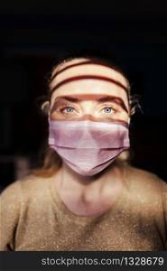 Woman wearing a surgical mask during quarantine in her house
