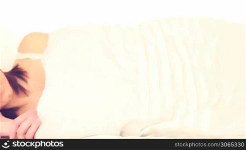 woman wearing a tank top sleeping, her head resting on a pillow