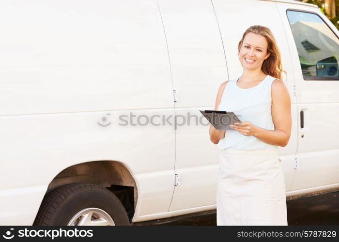 Woman Wearing Apron With Digital Tablet In Front Of Van