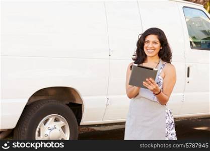Woman Wearing Apron With Digital Tablet In Front Of Van