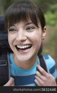 Woman wearing backpack, smiling, close-up
